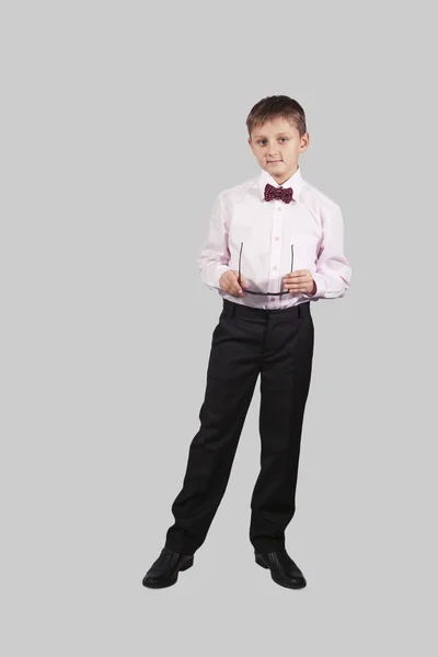 Wachstumsporträt eines Jungen mit Fliege, der die Brille in der Hand hält — Stockfoto