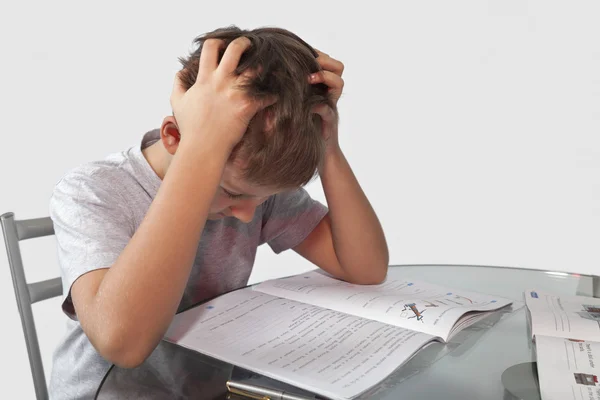 Garçon fait ses devoirs sur une table en verre Photos De Stock Libres De Droits