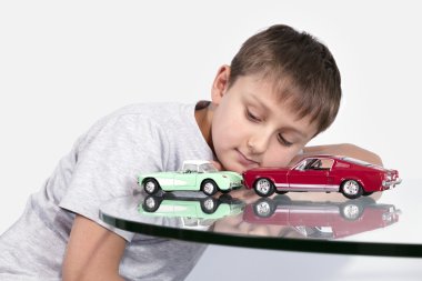 İki oyuncak araba ile oynayan çocuk