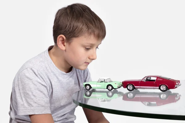 Garçon jouer avec deux voitures jouet Photo De Stock