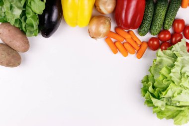 Çeşitli sebzelerin, patateslerin, soğanların, biberlerin, domateslerin, patlıcanların, beyaz arka planda salatanın, üst görünümün, aşağıdan kopyalama alanının fotoğrafı.