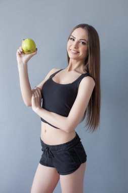 Cheerful young woman is eating healthy food