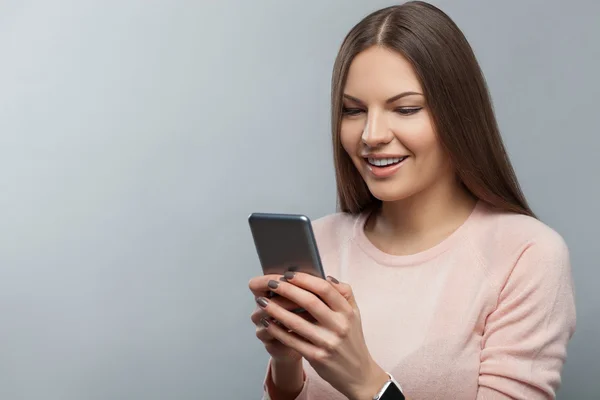 Jovem alegre está usando um telefone celular — Fotografia de Stock