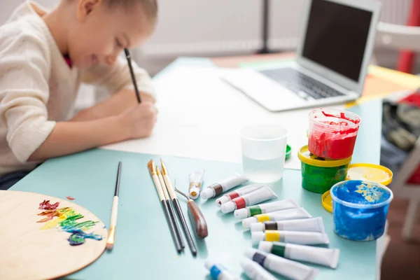Cheerful female child is painting at home — Stok fotoğraf