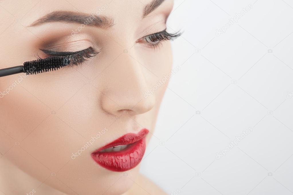 Attractive girl is putting on make-up