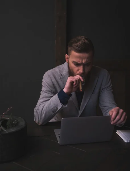 Привлекательный бородатый мужчина работает с ноутбуком — стоковое фото