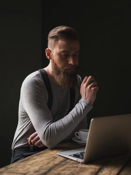 Привлекательный молодой бизнесмен пользуется компьютером — стоковое фото