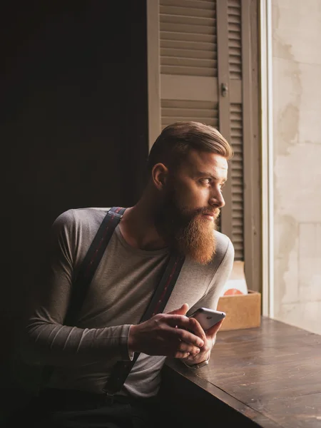 Привлекательный бородатый парень пишет по телефону — стоковое фото