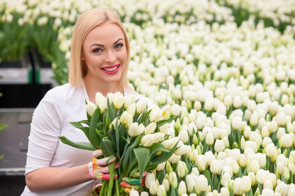 Hermosa jardinera femenina con bonitas flores de primavera — Foto de Stock