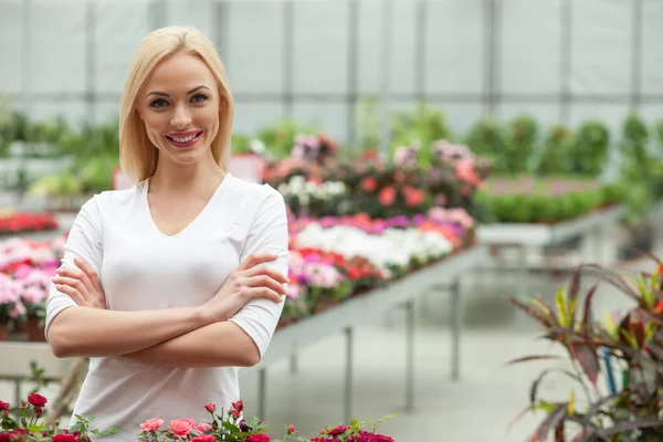 Attractive young gardener is working in greenhouse — Stock Photo, Image