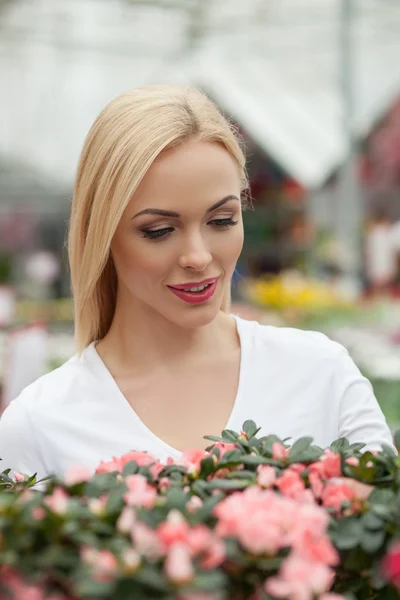 Jolie jeune femme dans un magasin de fleurs — Photo