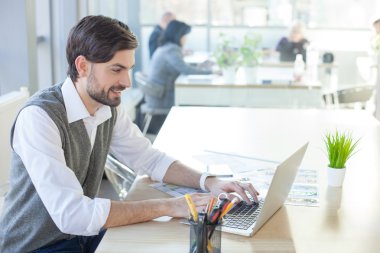 Çekici erkek tasarımcı dizüstü bilgisayar ile çalışıyor