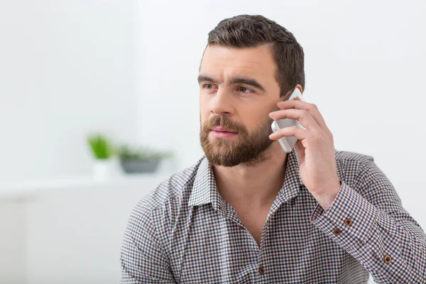 Attractive bearded guy is communicating on a telephone — Stock Photo, Image