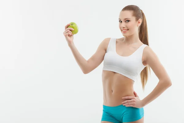 Aantrekkelijke jonge Sportvrouw met een groen fruit — Stockfoto