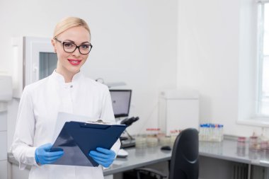 Neşeli genç bilim adamı laboratuvarda çalışıyor