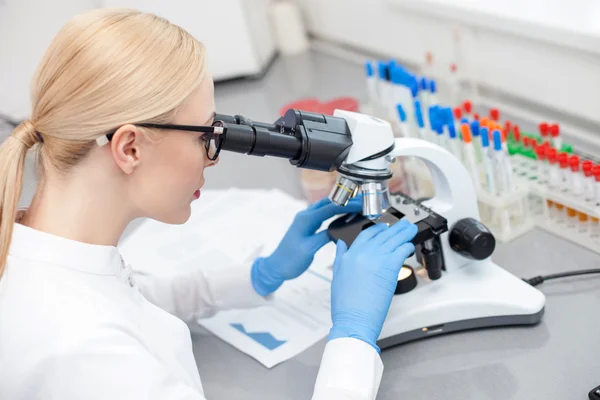 Asistente de laboratorio joven hábil está haciendo un análisis más detallado — Foto de Stock