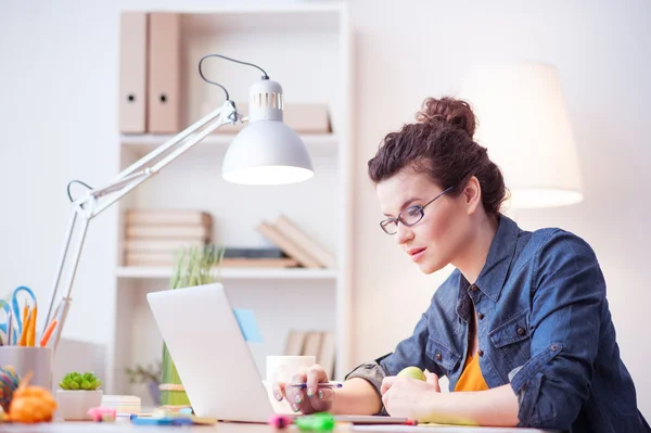 Freelancer feminino atraente está trabalhando em casa — Fotografia de Stock