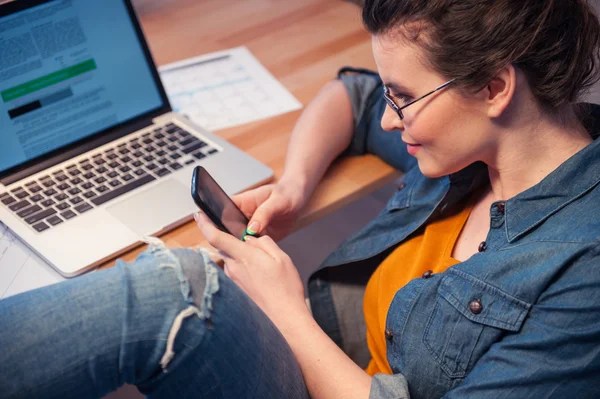 Hermosa joven está usando un teléfono — Foto de Stock