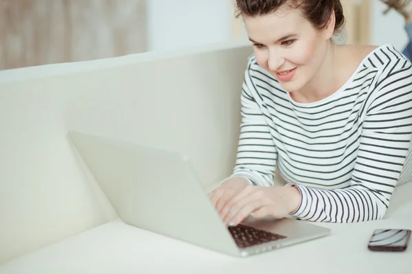 Joyeux jeune femme utilise un cahier — Photo