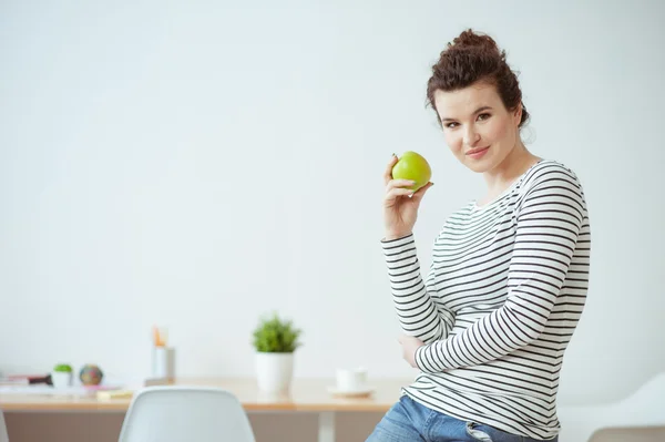 Bella ragazza in forma sta godendo di frutta verde — Foto Stock