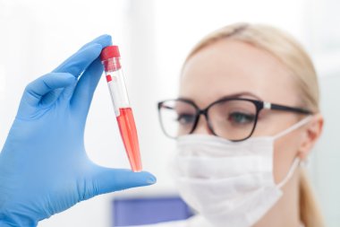 Usta kadın bilim adamı cam tüp inceliyor