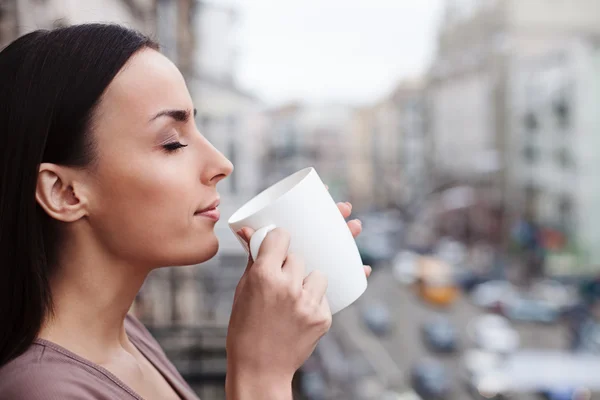 Aantrekkelijke jonge vrouw is het drinken van warme drank — Stockfoto