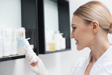 Güzel genç kozmetolojist kozmetik seçiyor