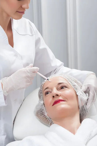 Весела експертка косметолог обслуговує свого пацієнта — стокове фото