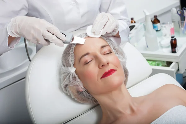 Skillful female beautician is undergoing laser treatment — Stock Photo, Image