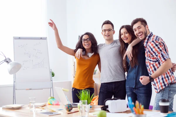 Quatro colegas alegres estão comemorando seu sucesso — Fotografia de Stock