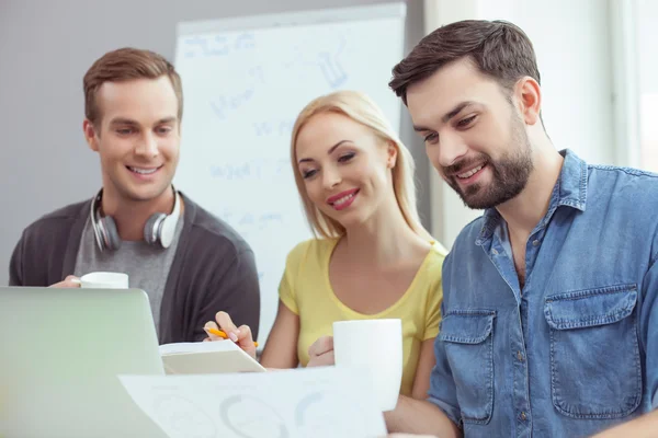 Gut gelaunt arbeiten drei Kollegen an Projekt — Stockfoto