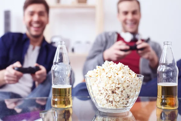 Cute young guys are playing video games — Stock Photo, Image