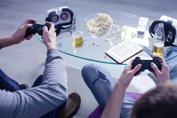 Cheerful two friends are entertaining in play-station — Stock Photo, Image