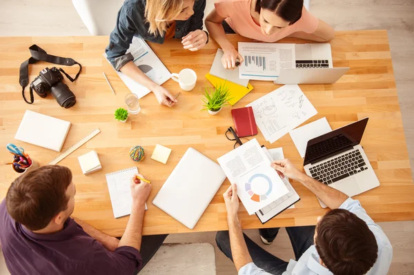 Cuatro hábiles colegas están discutiendo su trabajo — Foto de Stock