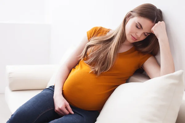 Ziemlich schwangere Frau ruht sich auf Sofa aus — Stockfoto