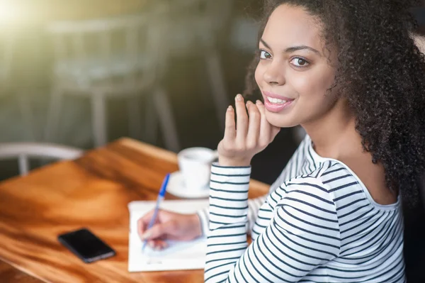 Fröhliche junge Frau studiert in Café — Stockfoto