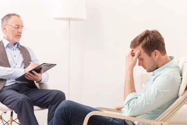 Un tipo atractivo está consultando a un psicoterapeuta. — Foto de Stock