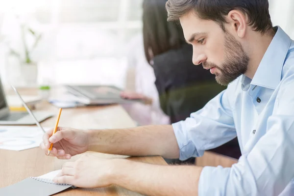 El joven atractivo está tomando notas. — Foto de Stock