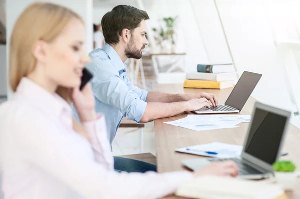 Chica alegre y chico están utilizando la tecnología moderna — Foto de Stock