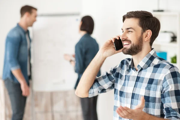 Allegro lavoratore maschile è la comunicazione al telefono — Foto Stock