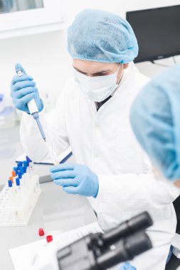 Neşeli iki araştırmacı laboratuvarda testler yapıyor