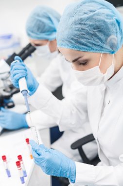Yetenekli iki araştırmacı laboratuvarda virüs test ediyor