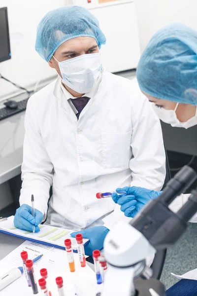 Professionele wetenschappers analyseren vloeistof in laboratorium — Stockfoto