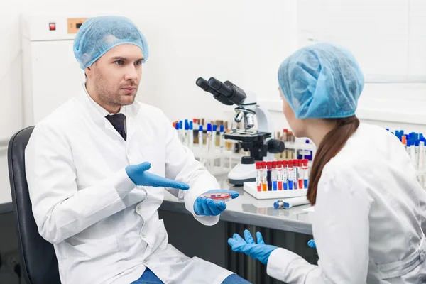 Vrolijke jonge onderzoekers hebben het over experiment — Stockfoto