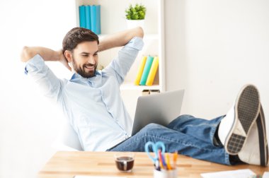 Çekici adam bir dizüstü bilgisayar ile rahatlatıcı