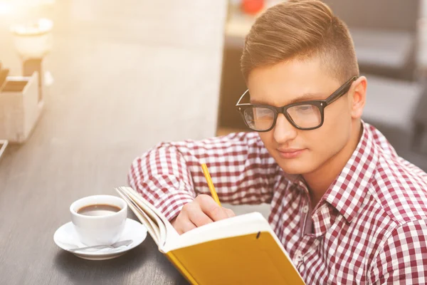 Knappe mannelijke student studeert in café — Stockfoto
