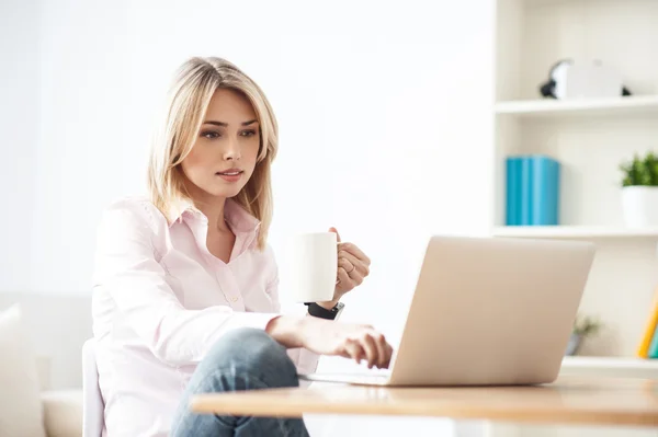 Fröhliches blondes Mädchen arbeitet am Computer — Stockfoto