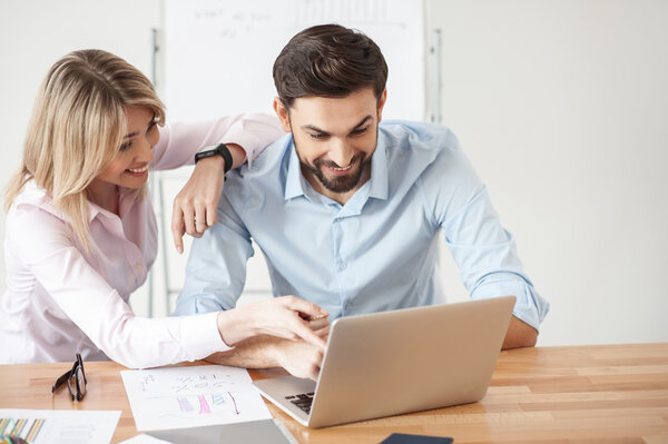 Cheerful two workers are talking in office