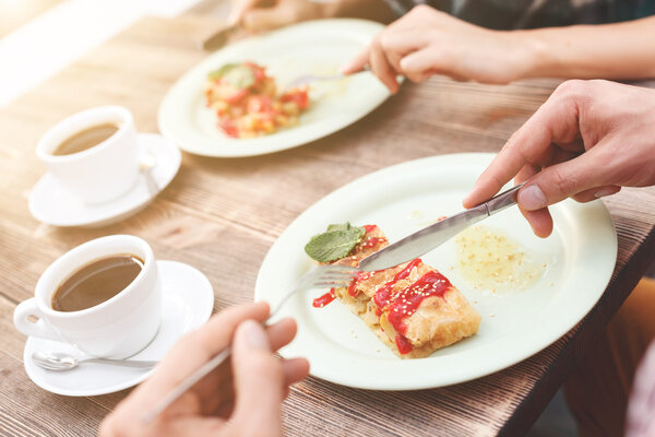 Pretty guy and girl are having breakfast