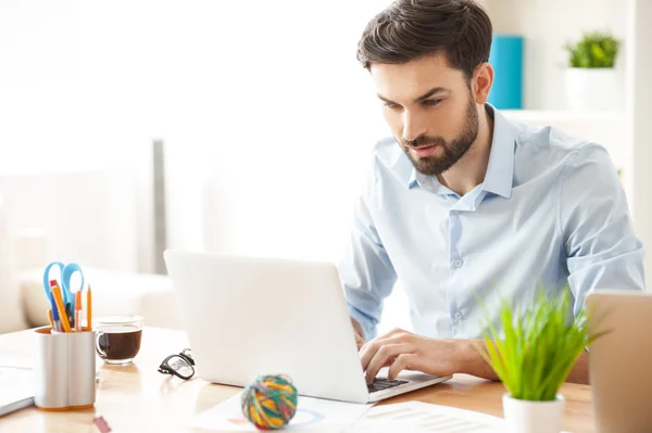 Alegre trabajador masculino está utilizando la tecnología moderna —  Fotos de Stock